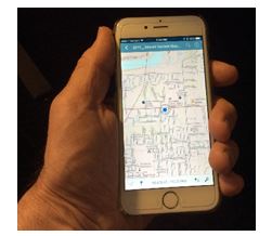 A hand holding a phone with a map on the screen
